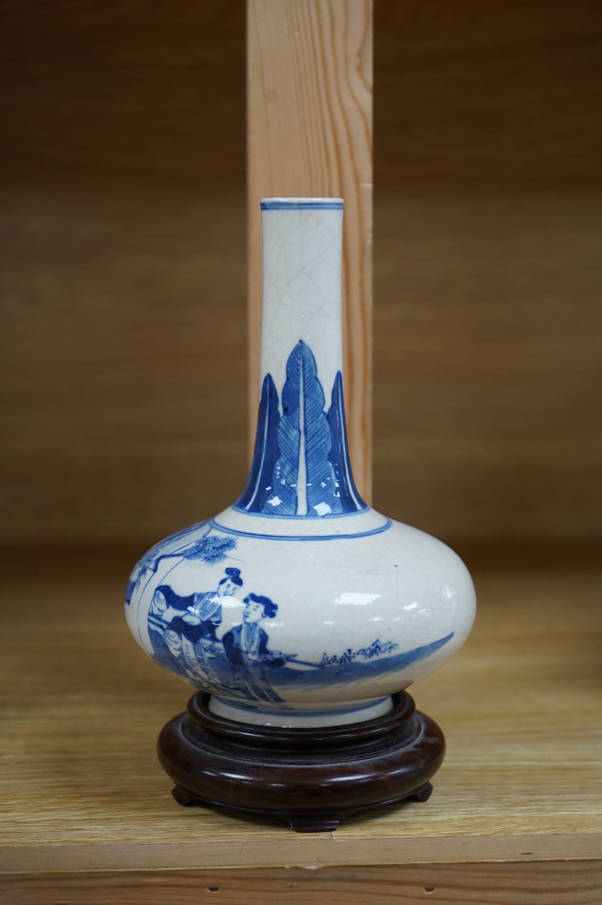 A 19th century Chinese blue and white crackle glaze bottle vase on hardwood stand, 20cm total. Condition - firing cracks to neck interior